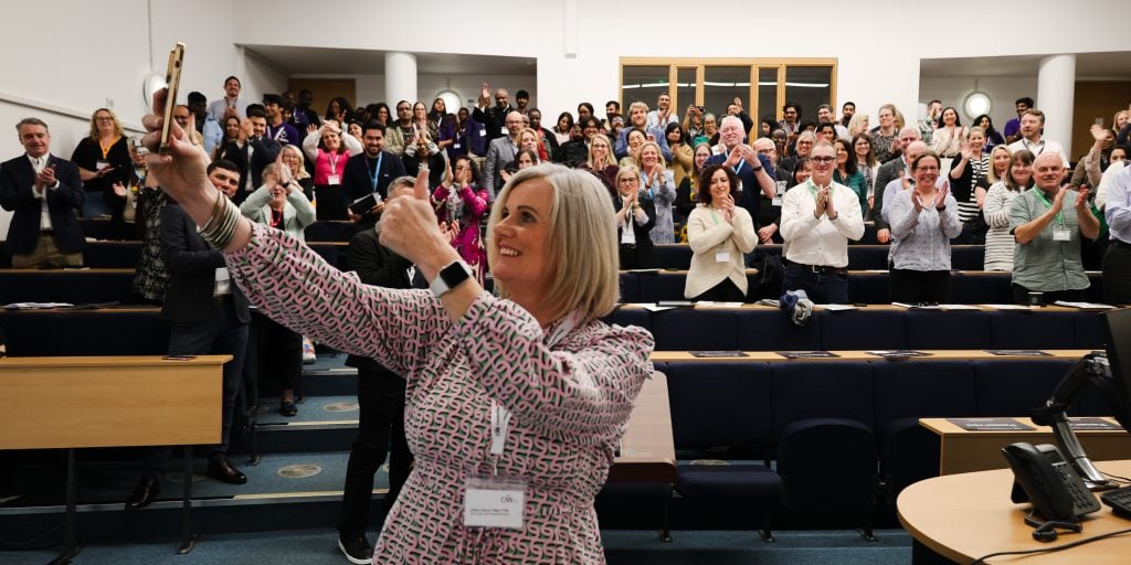 A person taking a selfie with a crowd