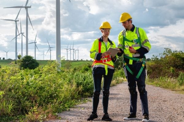 Some people stood in front of wind turbines